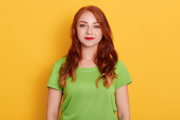 Photo of fresh beautiful woman with smile, looking directly at camera, wearing green t shirt, red...