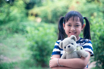 Smile little child girl hugging teddy bear with love