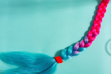 Pigtail multicolored mane unicorn. a strand of hair on a blue background © YuliiaMazurkevych