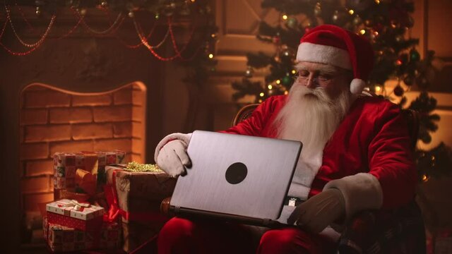 Santa Claus warm atmosphere in living room using laptop.