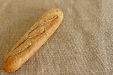 French baguette on sackcloth material, fresh bread on burlap