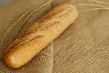 French baguette on sackcloth material, fresh bread on burlap