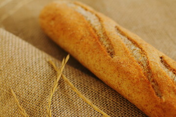 French baguette on sackcloth material, fresh bread on burlap