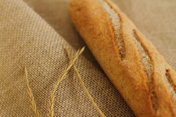 French baguette on sackcloth material, fresh bread on burlap