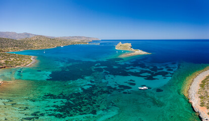 Fototapeta na wymiar Aerial view of the coastline of Crete surrounded by the clear waters of the Aegean Sea in summer