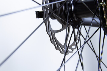 Bicycle disc brakes and spokes. Close-up on light background