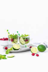Mojito cocktail with lime, raspberry and mint in a glass. Fresh summer cocktail. Summer mojito