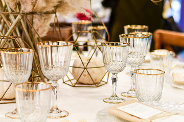 Luxury hotel table setting crystal wine glass and gold forks and knives. Catering banquet. table decor for celebration Wedding, anniversary, christmas, new year. table settin g restaurant.