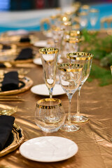 Luxury hotel table setting crystal wine glass and gold forks and knives. Catering banquet. table decor for celebration Wedding, anniversary, christmas, new year. table settin g restaurant.