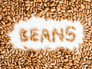 Overhead shot of beans with their name formed by beans on white background.