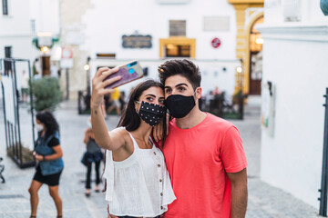 Pareja paseando por pueblo blanco de andalucia y tomando selfies