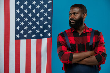 Young bearded African-american worker in flannel with his arms crossed by chest