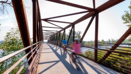  Cyclers ride across a scenic bridge above the Boise River