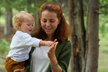 mom holding a small child walking in the park