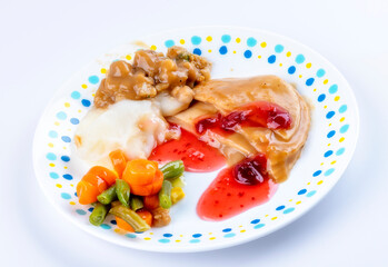 Turkey dinner served on a plate with vegetables and cranberries