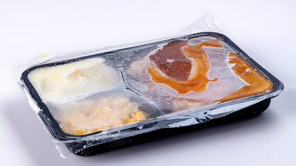 TV dinner sealed in cellophane still in a frozen state