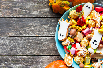 Halloween Jack o Lantern candy bowl with candy and halloween cookies Trick or Treat on wooden background