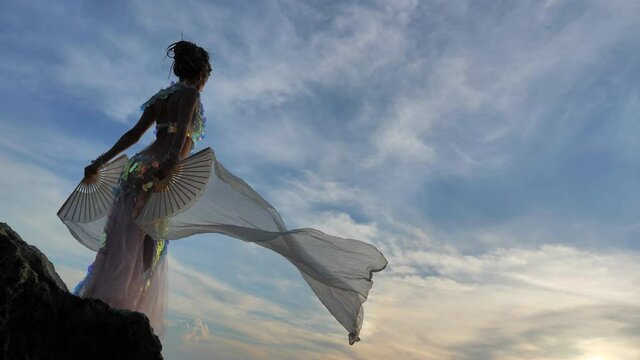 Magical fairy posing on a rocky sea shore