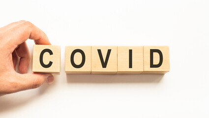 Word Covid. Wooden small cubes with letters isolated on white background with copy space available. Medicine concept