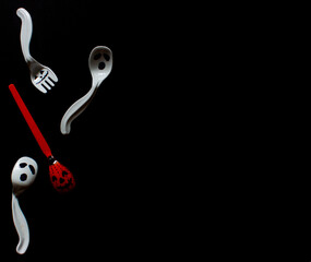 holidays, decorations and party concept-scary spoons and forks for Halloween on a black background. High quality photo