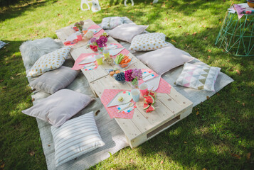 Kid birthday outdoor garden party table, pillows, bright colors