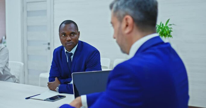 Black businessman listens to business partner, company strategies and development plans. Meeting of partners of different nationalities, a black employee listens to the director of the company. 4k