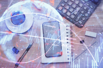 Multi exposure of forex graph hologram over desktop with phone. Top view. Mobile trade platform...