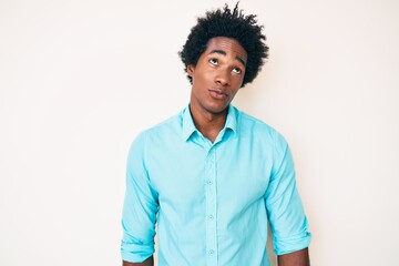 Handsome african american man with afro hair wearing casual clothes smiling looking to the side and staring away thinking.