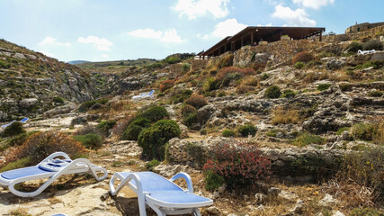 Sunbeds on the cliffs of Mgarr Ix-Xini, Gozo, Malta