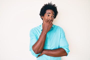 Handsome african american man with afro hair wearing casual clothes looking stressed and nervous with hands on mouth biting nails. anxiety problem.