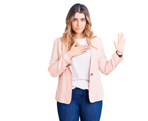 Young caucasian woman wearing business clothes swearing with hand on chest and open palm, making a...