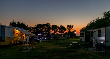 Motorhome and trailers parked in a Rv park at sunset on a beautiful evening 