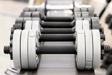 Dumbbells on rack in the gym, selective focus. Concept for weightlifting, bodybuilding, fitness center, sports