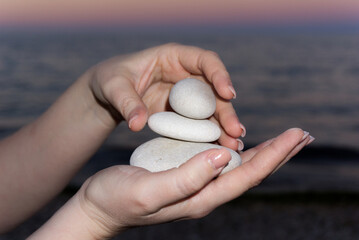 Ciottoli o sassi in mano mentre vengono disposti per formare una colonna