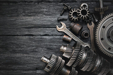 A car gearbox spare parts and wrenches on black background with copy space.