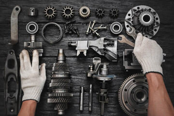 Car gearbox spare parts and car service worker hands with wrenches on the black flat lay background.