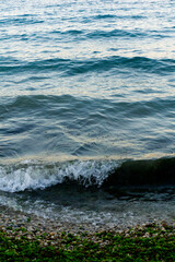 Onda che bagna la riva di una spiaggia piena di sassi
