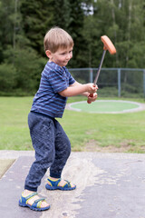enfant garçon joue au mini golf