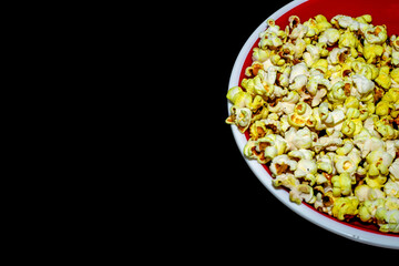 Popcorn viewed from above on black background.