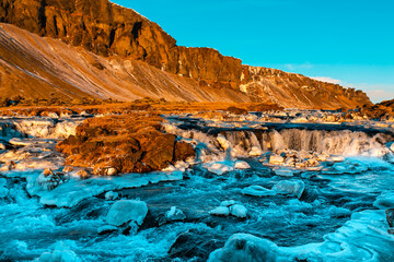 Iceland's breathtaking mountain landscape in winter, a river with a waterfall. Nature paints