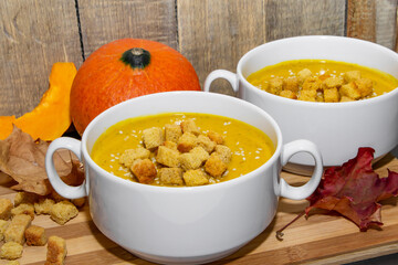 Autumn pumpkin soup with sesame seeds on a wooden background