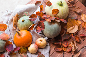 Happy thanksgiving text with pumpkins, apples and leaves on a green lawn background