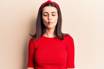 Young beautiful girl wearing casual t shirt and diadem making fish face with lips, crazy and comical gesture. funny expression.