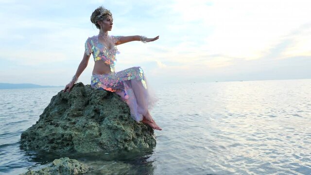 Magical fairy posing on a rocky sea shore