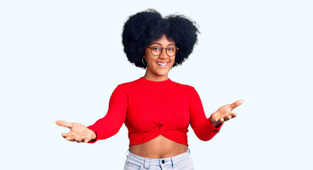 Young african american girl wearing casual clothes and glasses smiling cheerful offering hands giving assistance and acceptance.