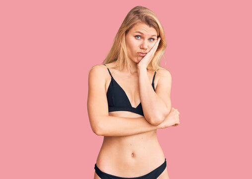 Young beautiful blonde woman wearing bikini thinking looking tired and bored with depression problems with crossed arms.