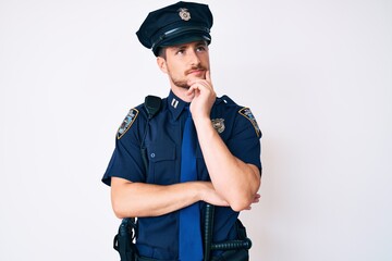Young caucasian man wearing police uniform with hand on chin thinking about question, pensive expression. smiling and thoughtful face. doubt concept.