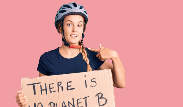 Beautiful caucasian woman holding there is no planet b banner pointing finger to one self smiling happy and proud