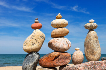 Several Rock zen pyramids of colorful pebbles on a beach on the background of the sea. Concept of balance, harmony and meditation.
