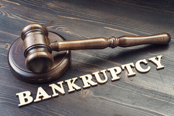 Judges gavel on desk and word bankruptcy spelled in wooden letters